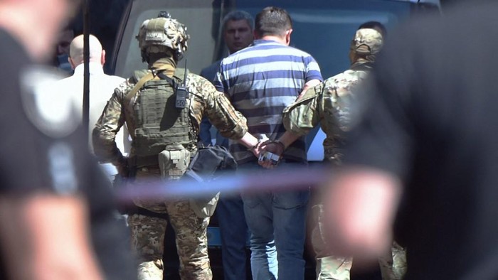 A man is arrested by Ukraines special forces officers after he threatens to detonate a grenade inside the government building in Kiev on August 4, 2021. (Photo by Sergei SUPINSKY / AFP)