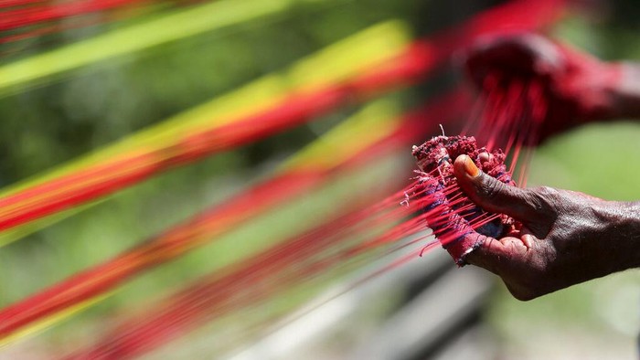 An Indian thread maker prepares colored threads for flying kites in Jammu, India, Tuesday, Aug. 3, 2021. The demand for these threads goes up in August when people in northern India fly kites and peaks during Independence Day, which falls on August 15. (AP Photo/Channi Anand)