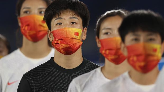 YOKOHAMA, JAPAN - JULY 27: Shimeng Peng #12 of Team China wears a face mask with teammates as they stand for the national anthem prior to the Women's Group F match between Netherlands and China on day four of the Tokyo 2020 Olympic Games at International Stadium Yokohama on July 27, 2021 in Yokohama, Kanagawa, Japan. (Photo by Francois Nel/Getty Images)