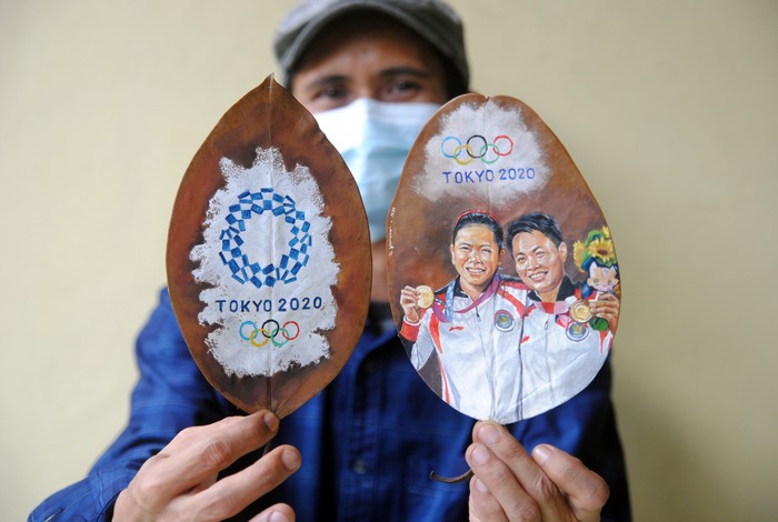 APRESIASI SENIMAN ATAS EMAS OLIMPIADE GRESYIA/APRIYANI Pelukis Teddy Arte menunjukkan lukisan daun kering ganda putri Indonesia peraih medali emas Olimpiade Tokyo 2020, Greysia Polii dan Apriyani Rahayu di Desa Cilebut Timur, Sukaraja, Kabupaten Bogor, Jawa Barat, Kamis (5/8/2021). Lukisan daun kering yang diselesaikan dalam waktu dua hari tersebut sebagai bentuk penghargaan seniman atas prestasi ganda putri Indonesia yang berhasil meraih medali emas pada cabang olahraga bulutangkis Olimpiade Tokyo 2020. ANTARA FOTO/Arif Firmansyah/aww.