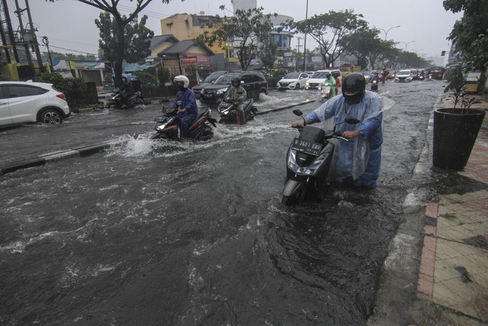 Pengendara mendorong sepeda motor yang mogok saat melintasi genangan air di Jalan Margonda Raya, Depok, Jawa Barat, Kamis (5/8/2021). Genangan setinggi 30 cm hingga 60 cm merendam kawasan tersebut akibat tingginya curah hujan serta drainase yang buruk. ANTARA FOTO/Asprilla Dwi Adha/aww.