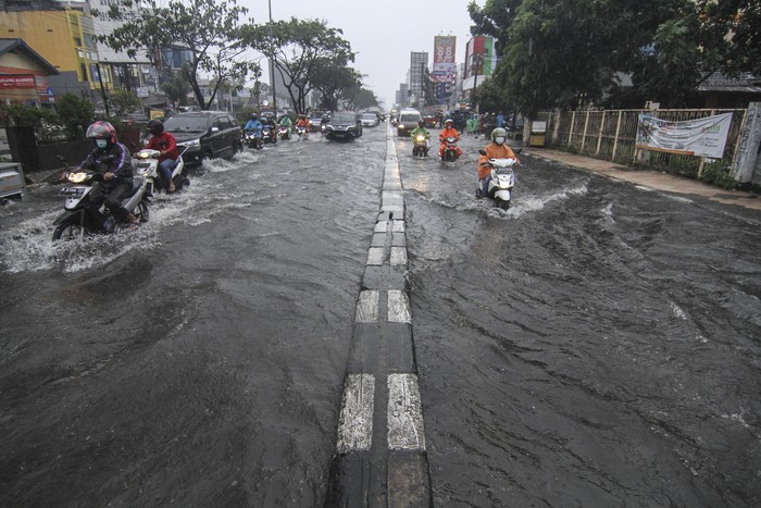Pengendara mendorong sepeda motor yang mogok saat melintasi genangan air di Jalan Margonda Raya, Depok, Jawa Barat, Kamis (5/8/2021). Genangan setinggi 30 cm hingga 60 cm merendam kawasan tersebut akibat tingginya curah hujan serta drainase yang buruk. ANTARA FOTO/Asprilla Dwi Adha/aww.