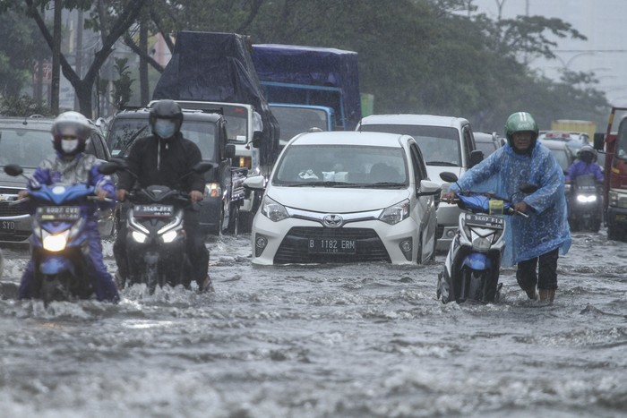 Pengendara mendorong sepeda motor yang mogok saat melintasi genangan air di Jalan Margonda Raya, Depok, Jawa Barat, Kamis (5/8/2021). Genangan setinggi 30 cm hingga 60 cm merendam kawasan tersebut akibat tingginya curah hujan serta drainase yang buruk. ANTARA FOTO/Asprilla Dwi Adha/aww.