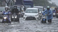 Pengendara mendorong sepeda motor yang mogok saat melintasi genangan air di Jalan Margonda Raya, Depok, Jawa Barat, Kamis (5/8/2021).