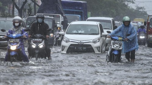 Pengendara mendorong sepeda motor yang mogok saat melintasi genangan air di Jalan Margonda Raya, Depok, Jawa Barat, Kamis (5/8/2021). Genangan setinggi 30 cm hingga 60 cm merendam kawasan tersebut akibat tingginya curah hujan serta drainase yang buruk. ANTARA FOTO/Asprilla Dwi Adha/aww.