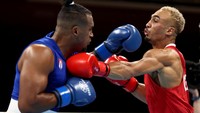 Whittaker (merah) bertukar pukulan dengan Arlen Lopez dari Kuba, keduanya berada pada kelas berat ringan (75-81kg). Buda Mendes/Getty Images