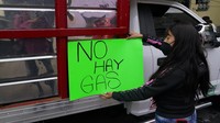 Seorang wanita memasang penandang bertuliskan No Gas di badan truk pengiriman gas LP yang berada di Kota Meksiko, Rabu (4/8/2021) waktu setempat.