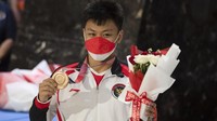 Peraih medali perunggu cabor angkat besi, Rahmat Erwin Abdullah, tiba dengan mengenakan medali yang diraihnya.  