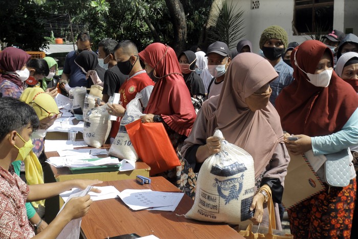 Warga mengangkat bantuan sosial tambahan berupa 10 kilogram beras yang diterimanya di Kelurahan Harapan Jaya, Cibinong, Kabupaten Bogor, Jawa Barat, Kamis (5/8/2021). Perum Bulog menyalurkan tambahan bantuan beras untuk warga terdampak PPKM yang ditujukan kepada 10 juta Keluarga Penerima Manfaat (KPM) Bantuan Sosial Tunai dan 10 juta KPM Program Keluarga Harapan sesuai data dari Kemensos. ANTARA FOTO/Yulius Satria Wijaya/wsj.
