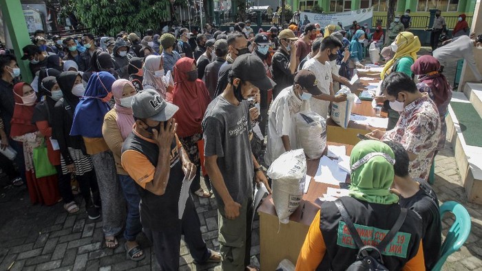 PENYALURAN BANTUAN SOSIAL TAMBAHAN BERUPA BERAS Warga mengangkat bantuan sosial tambahan berupa 10 kilogram beras yang diterimanya di Kelurahan Harapan Jaya, Cibinong, Kabupaten Bogor, Jawa Barat, Kamis (5/8/2021). Perum Bulog menyalurkan tambahan bantuan beras untuk warga terdampak PPKM yang ditujukan kepada 10 juta Keluarga Penerima Manfaat (KPM) Bantuan Sosial Tunai dan 10 juta KPM Program Keluarga Harapan sesuai data dari Kemensos. ANTARA FOTO/Yulius Satria Wijaya/wsj.