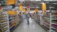 Calon pembeli berdiri di antara deretan rak kebutuhan sehari-hari.