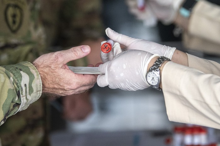 Petugas kesehatan menyerahkan alat tes usap Polymerase Chain Reaction (PCR) kepada tentara Amerika saat tiba di Bandara International Sultan Mahmud Baddarudin (SMB) II Palembang, Sumatera Selatan, Minggu (25/7/2021). Tentara Amerika yang akan mengikuti Latihan Bersama Garuda Shield ke 15/2021 tersebut harus menjalani test PCR dengan metode usap sebagai penerapan protokol kesehatan. ANTARA FOTO/Nova Wahyudi/rwa.