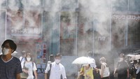 Warga menggunakan masker di bawah semprotan air untuk meredam hawa panas di Tokyo (5/8). Meski terjadi kenaikan kasus Corona, PM Suga dan penyelenggara Olimpiade menyatakan tidak ada kaitan antara Olimpiade pada 23 Juli hingga 8 Agustus dengan lonjakan tajam kasus Corona. 