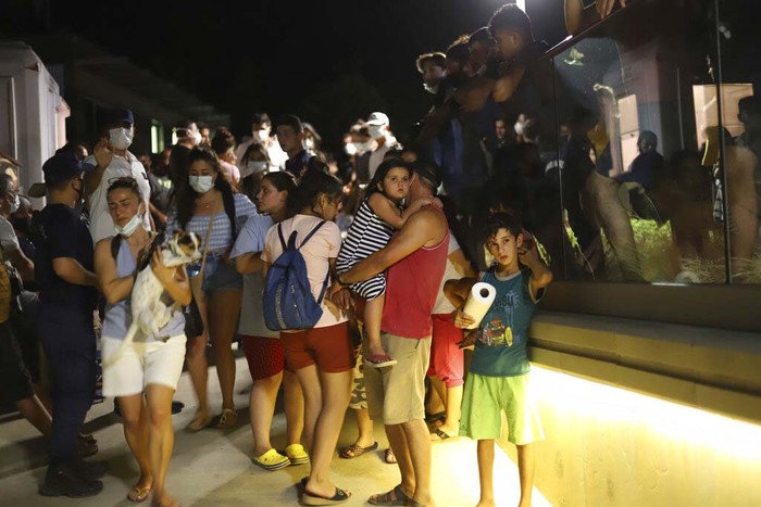 Turkey Wildfires People wait to be evacuated by boats after wildfires reached the Kemerkoy Power Plant, a coal-fueled power plant, in Milas in southwest Turkey, late Wednesday, Aug. 4, 2021. (AP Photo/Cem Tekkesoglu)
