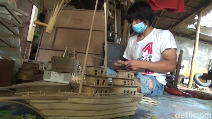 Aep, penyandang disabilitas asal Purwakarta tengah membuat perahu pinisi.