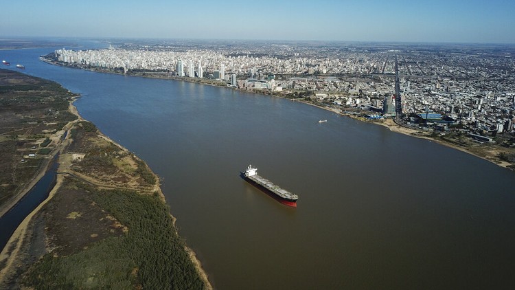 Nestapa Keringnya Salah Satu Sungai Terpanjang Dunia Birds fly over a man taking photos of the exposed riverbed of the Old Parana River, a tributary of the Parana River during a drought in Rosario, Argentina, Thursday, July 29, 2021. (AP Photo/Victor Caivano)