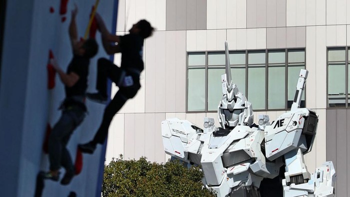 Robot gundam raksasa mejeng di sejumlah tempat di Jepang. Bahkan robot raksasa itu juga 'memelototi' aksi atlet panjat tebing dan balap sepeda. Begini penampakan robot tersebut.