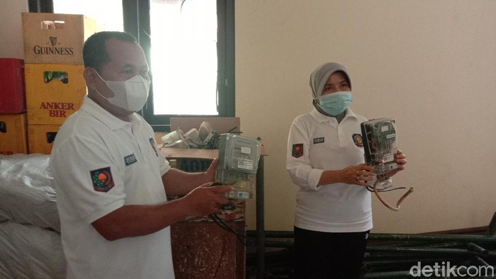 Petugas menunjukkan meteran listrik yang disita dari kafe karaoke