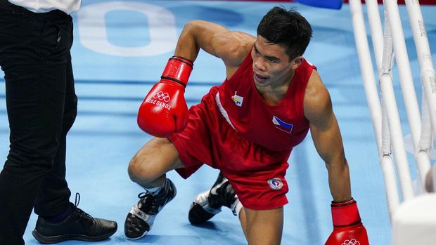 Carlo Paalam, of the Philippines, gets up after a punch from Britain's Galal Yafai during their men's flyweight 52-kg boxing gold medal match at the 2020 Summer Olympics, Saturday, Aug. 7, 2021, in Tokyo, Japan. (AP Photo/Frank Franklin II)