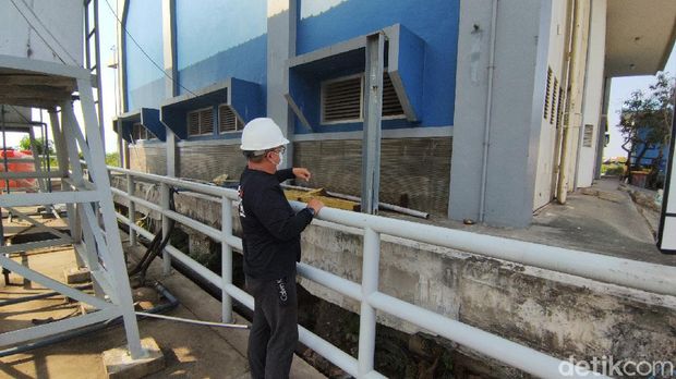 Kepala UPTD Pengelola Pompa Banjir Wilayah Tengah II Semarang dan petugasnya menunjukkan  alat ukur manual penurunan tanah, Sabtu (7/8/2021).