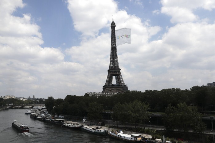 FILE - In this June 8, 2021, file photo, a giant flag flies at the Eiffel Tower during a a test flight in Paris. A giant flag will be flown from the Eiffel Tower like this one on Sunday, Aug. 8, during the Tokyo Olympics closing ceremony that 2024 Paris Olympics organizers claim will be the biggest ever seen. (AP Photo/Lewis Joly, File)