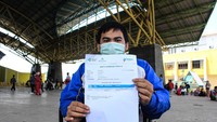 Seorang penyandang disabilitas menunjukkan kartu vaksinasi COVID-19.