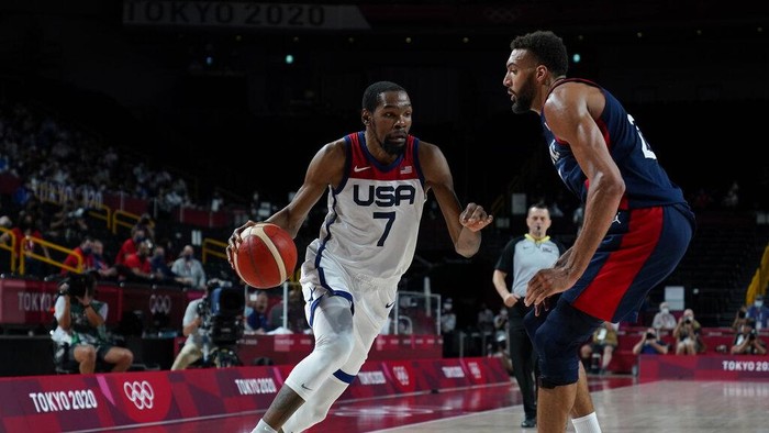 United States Kevin Durant (7) drives around Frances Rudy Gobert (27) during mens basketball gold medal game at the 2020 Summer Olympics, Saturday, Aug. 7, 2021, in Saitama, Japan. (AP Photo/Charlie Neibergall)