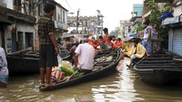 Penduduk desa bersiap-siap mengungsi saat banjir mulai melanda di desa Khanakul, Bangladesh, (4/8). Curah hujan tinggi menyebabkan air memasuki jalanan desa tersebut. AP Photo/Ashim Paul  