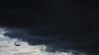 Pesawat komersial melintas di dekat awan hujan di Frankfurt, Jerman (2/8/2021). Hujan turun dengan intensitas tinggi di beberapa kota di Jerman. Arne Dedert/dpa via AP  