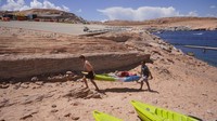 Pengunjung mengangkat kayak di Danau Powell yang mengering di Arizona, AS (31/7). Musim panas ini merupakan cuaca terkering dan terpanas dalam sejarah barat AS. AP Photo/Rick Bowmer  
