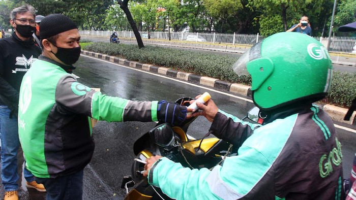 Berbagai cara dilakukan orang untuk berbagai di masa pandemi ini. Termasuk membagikan hand sanitizer untuk para pengemudi ojek online.