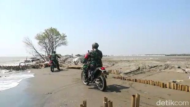 Personel TNI menggunakan motor untuk menjangkau warga