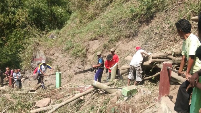 Proses pembersihan material longsor di jalan menuju Dusun Gir Pasang, Klaten, Minggu (8/8/2021).