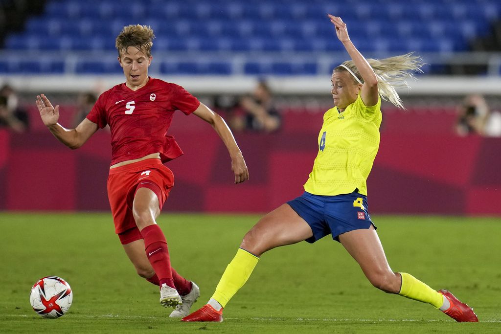 Canada's Quinn, left, and Sweden's Hanna Glas battle for the ball in the women's soccer match for the gold medal at the 2020 Summer Olympics, Friday, Aug. 6, 2021, in Yokohama, Japan. (AP Photo/Fernando Vergara)