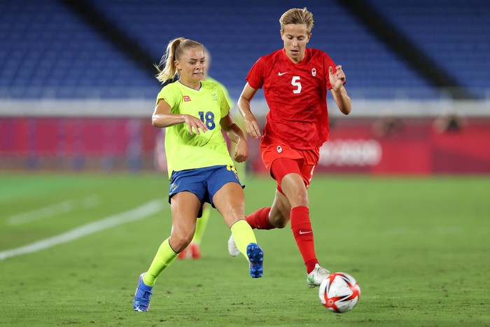 YOKOHAMA, JAPAN - AUGUST 06: Fridolina Rolfo #18 of Team Sweden makes a pass whilst under pressure from Quinn #5 of Team Canada during the Womens Gold Medal Match between Canada and Sweden on day fourteen of the Tokyo 2020 Olympic Games at International Stadium Yokohama on August 06, 2021 in Yokohama, Kanagawa, Japan. (Photo by Naomi Baker/Getty Images)