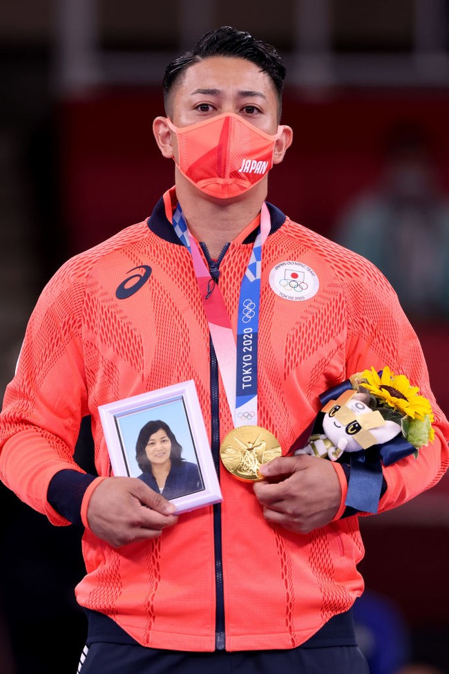 Bangga sekaligus haru, dia membawa foto mendiang ibunya yang telah meninggal dua tahun lalu. Foto: Getty Images/Harry How