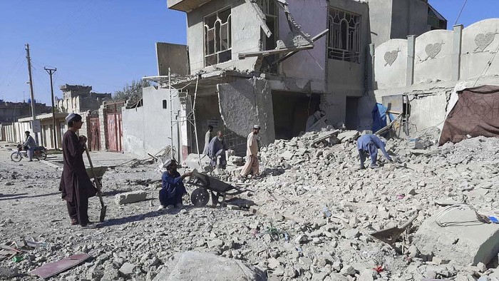 Serangan Taliban di Kota Lashkar Gah Afghanistan Hancurkan Klinik Afghans inspect a damaged building after airstrikes in Lashkar Gah city of Helmand province, southern of Kabul, Afghanistan, Sunday, Aug. 8, 2021. Airstrikes in southern Afghanistan damaged a health care clinic and high school in the capital of Helmand province, a provincial council member said Sunday. (AP Photo/Abdul Khaliq)