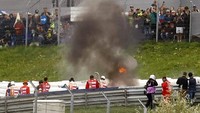 Pemandangan motor terbakar yang sempat bikin balapan terhenti sesaat.  (Foto: AFP/ERWIN SCHERIAU)