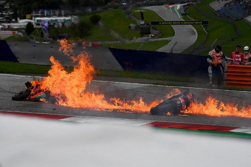 Motorbikes are on fire following a crash involving Aprilia Italian rider Lorenzo Savadori and KTM Spanish rider Dani Pedrosa after the start of the Styrian Motorcycle Grand Prix at the Red Bull Ring race track in Spielberg, Austria on August 8, 2021. (Photo by JOE KLAMAR / AFP)