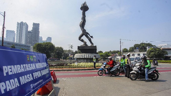 EVALUASI RENCANA PERPANJANGAN PPKM DARURAT Petugas kepolisian memeriksa kendaraan di tempat penyekatan Pemberlakuan Pembatasan Kegiatan Masyarakat (PPKM) Darurat di kawasan JalanJenderal Sudirman, Jakarta, Sabtu (17/7/2021). Menurut Menko PMK Muhadjir Effendy Pemberlakuan Pembatasan Kegiatan Masyarakat (PPKM) Darurat akan diperpanjang hingga akhir Juli. ANTARA FOTO/ Reno Esnir/nz