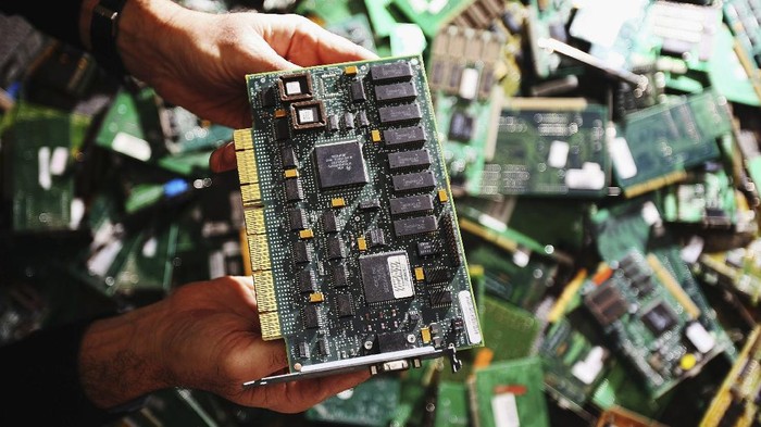 Foto: Medali Olimpiade Tokyo 2020 Dari Daur Ulang SYDNEY, AUSTRALIA - JUNE 04: Tony Domanski, Operations manager IT and Infrastructure for the Reverse Garbage Co-Op poses with printed circuit boards from a computer undergoing recycling June 4, 2007 in Sydney Australia. Modern machines such as computers and personal entertainment devices are being recycled by the Co-Op in Sydney's West, preventing them from ending up in landfill sites. The mother-boards and other usable materials are removed and re-used in re-built machines, and also sold on to artists for artwork. The so-called