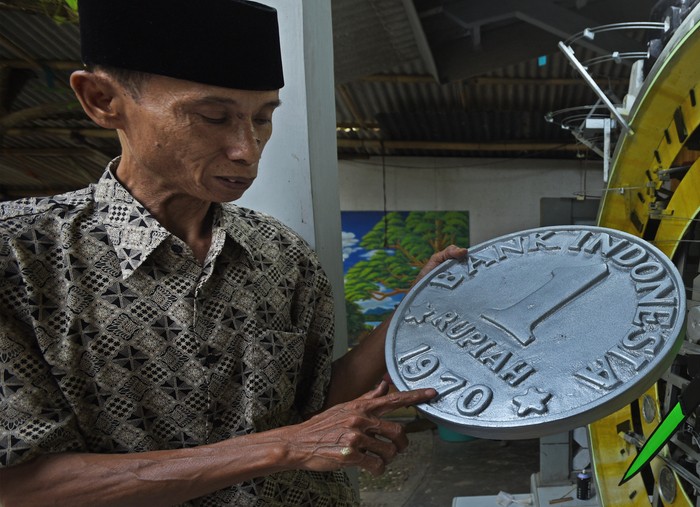 KERAJINAN DAUR ULANG BARANG BEKAS Perajin mengecat replika cincin kalimaya ukuran raksasa yang terbuat dari barang bekas di Kampung Sukawana, Serang, Banten, Senin (9/8/2021). Perajin yang juga berprofesi sebagai pengepul barang bekas memanfaatkan sebagian limbah logam dan plastik yang terkumpul untuk membuat sejumlah kreasi. ANTARA FOTO/Asep Fathulrahman/hp.