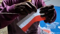 Karena berukuran kecil, seutas tali dimasukan ke sebuah jarum, setelah itu jarum tersebut dimasukan ke lubang yang ada di bendera itu.
