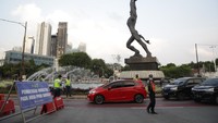 Petugas melakukan penyekatan di Jalan Jenderal Sudirman, Jakarta, Senin (9/8/2021).