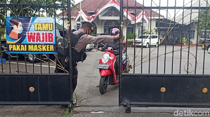 Potret Polisi Bersenjata Jaga Ketat Kantor Dinas PUPR Banjarnegara Polisi tampak bersiaga menjaga kantor Dinas PUPR Banjarnegara. Pengamanan diperketat usai KPK usut dugaan korupsi terkait pengadaan pada DPUPR Banjarnegara.