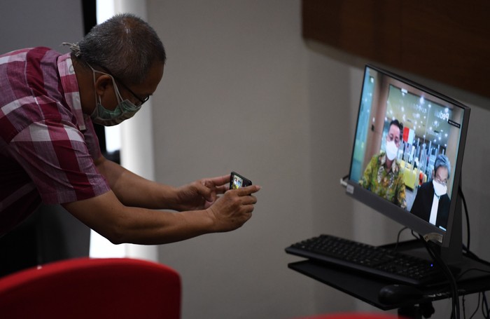 Pewarta memotret terdakwa kasus dugaan korupsi bansos Juliari Batubara melalui layar saat menjalani sidang lanjutan secara virtual di gedung KPK, Jakarta, Senin (9/8/2021). Sidang mantan Menteri Sosial itu beragenda pembacaan nota pembelaan atau pledoi. ANTARA FOTO/Akbar Nugroho Gumay/rwa.