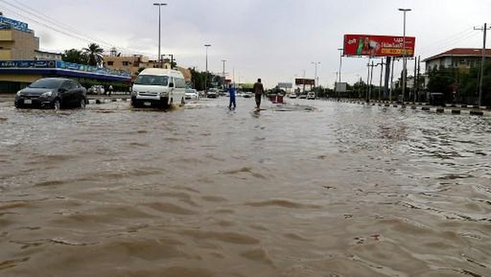 Cars drive along a flooded street in Khartoum after torrential rain fell on the Sudanese capital, almost paralising traffic, on August 8, 2021. - Flashfloods due to heavy rains swept through Sudan today, overwhelming the countrys already poor drainage systems, and reportedly destroying hundreds of homes in other parts. (Photo by ASHRAF SHAZLY / AFP)