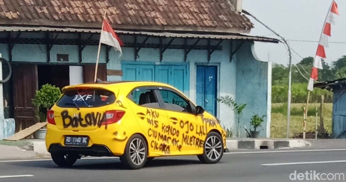 Waduh! Mobil Ini Dicorat-coret PPKM Sebuah mobil sedan Honda Brio berpenampilan nyleneh melintas di Jalan Yogya-Solo, Desa Ngawonggo, Kecamatan Ceper, Klaten, Jawa Tengah, Senin (9/8/2021) siang.