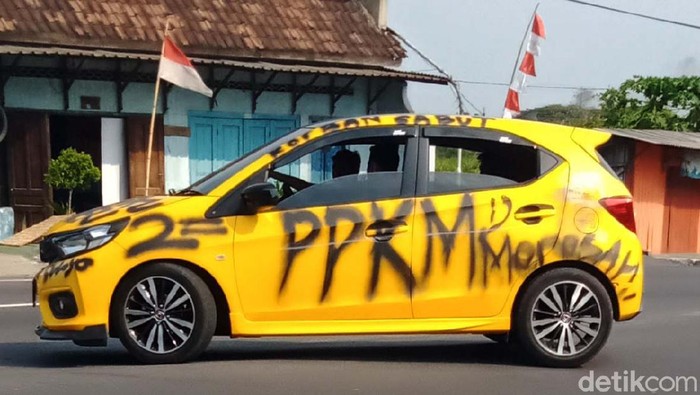 Waduh! Mobil Ini Dicorat-coret PPKM Sebuah mobil sedan Honda Brio berpenampilan nyleneh melintas di Jalan Yogya-Solo, Desa Ngawonggo, Kecamatan Ceper, Klaten, Jawa Tengah, Senin (9/8/2021) siang.