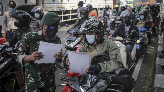 WAKTU PENYEKATAN PPKM DARURAT Anggota TNI memeriksa dokumen perjalanan pengemudi yang akan melintas di pos penyekatan pembatasan menuju Jakarta di kawasan Kalideres, Jakarta, Jumat (16/7/2021). Pemerintah memberlakukan waktu pembatasan mobilitas masyarakat yang tersebar pada 100 titik menjadi dua yakni penyekatan pada pukul 06.00-10.00 WIB untuk pekerja sektor esensial dan kritikan serta penutupan pada pukul 10.00-22.00 WIB kecuali tenaga kesehatan, dokter dan kendaraan darurat yang diperbolehkan melintas. ANTARA FOTO/Fauzan/foc.